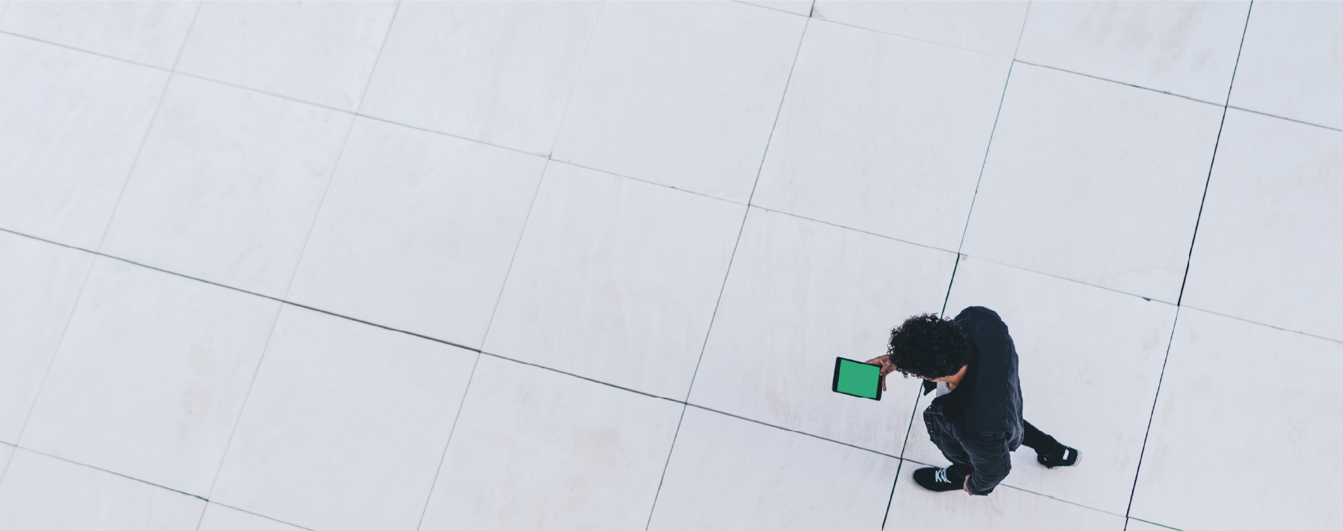 View of a man from above walking and looking at his mobile device